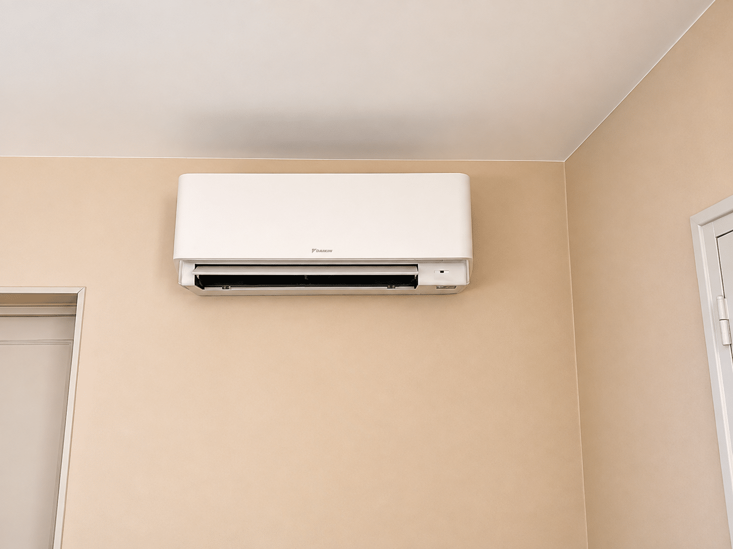 Climatiseur Daikin : Installation Murale Moderne Climatiseur mural blanc Daikin sur mur beige avec volet ouvert.